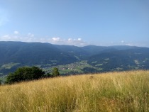 Idilični pogledi z Rebrnikovih travnikov na kotlino in pot, ki nas še čaka title=